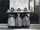 China: Three women wearing a cangue or form of portable stocks as a punishment, c. 1900.